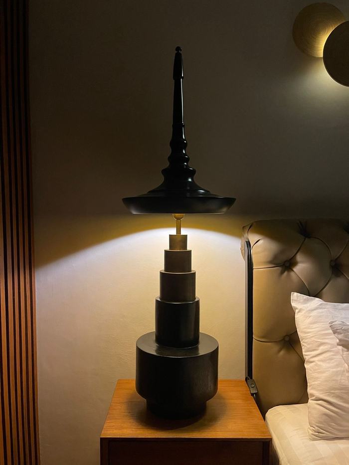 Close-up of black artisan lamp and bedside styling