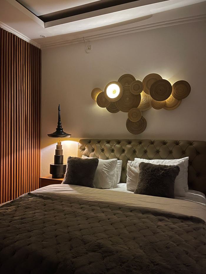 Second suite with tufted headboard, plush bedding, and statement lamp