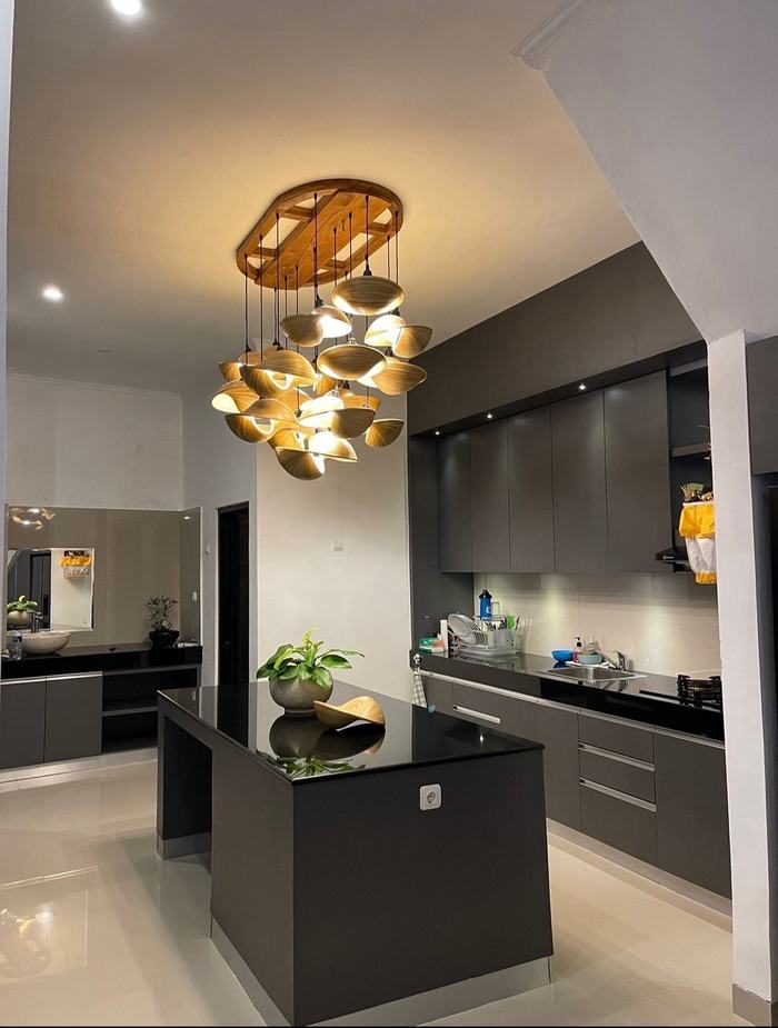 Charcoal kitchen with stone island and sculptural brass chandelier